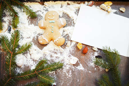 Blank greeting card with gingerbread man on kitchen table. Original Christmas congratulation. Fun at kitchen, cooking artの写真素材