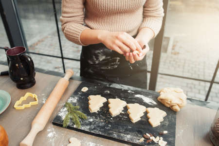 Gingerbread Christmas tree cookies on tray. Confectioner preparing sweet treat for family. Homemade bakery, xmas pastry, winter holidays conceptの写真素材