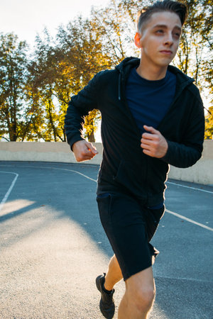 Close-up portrait of running sprinter. Blurred photo of very fast marathoner, training before competitions. Speed, fast runner, sport, healthy lifestyle conceptの写真素材
