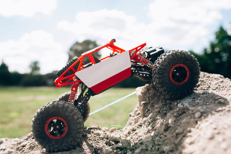 Side view on rc crawler rising on rock hill. Toy suv climbing on mountain road, profile. Extreme...
