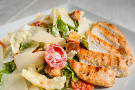 Caesar salad with fried chicken meat, free space. Restaurant serving of side dish with fried poultry and fresh vegetables. Mediterranean cuisine, appetizer, menu conceptの写真素材