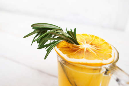 Close-up of orange juice with rosemary. Glass with citrus fresh drink and herb. Refreshment, recipe, menu, restaurant conceptの写真素材