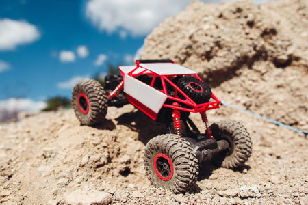 Rc car riding on rock land, close-up. Toy suv driving on offroad trace. Toy, competition,...