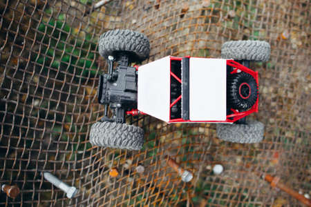 Rc truck on metal lattice, top view. Toy crawler riding on grille, suv driving facilities testing, free spaceの写真素材