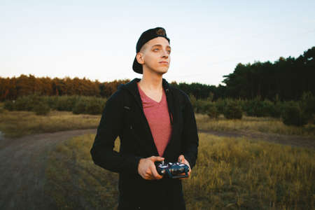 Pleased man looking for his new drone run. Young creative inventor testing upgraded sample of unmanned aerial vehicle. Hobby, success, electronics, innovation conceptの写真素材