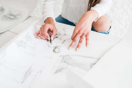 Artist hands drawing sketch on whatman or white paper. Female painter painting in studio. Stylish woman with mehendi oh hand working in workshop. Art, talent, craft, hobby, creativity conceptの写真素材