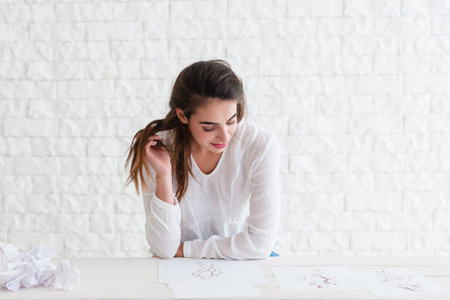 Attractive woman playing with her hair, free space. Beautiful smiling lady flirting with you, sitting at table. Love, sympathy, relationship conceptの写真素材