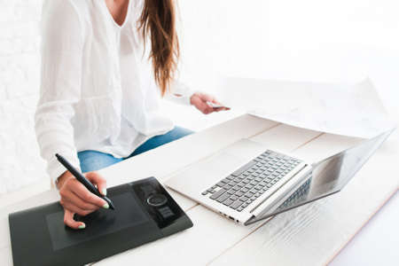 Unrecognizable artist or designer working on graphic tablet, free space. Woman artist drawing on technological painting device. Art, talent, craft, hobby, creativity conceptの写真素材