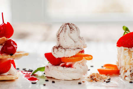 Creamy tasty sweet dessert close-up, free space. Variety of tasty pastries with fresh berries. Confectionery, restaurant bakery, delicatessen conceptの写真素材