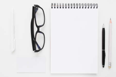 Blank notebook with stationery and glasses flat lay mockup. Top view on writer with bad vision work tools, free space. Art, business, creation, imagination, stationery, workplace,orderliness conceptの写真素材