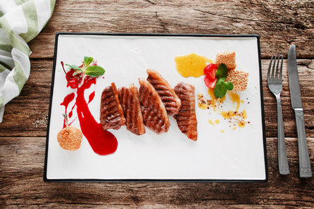 Pork steaks served with sweet sauce flat lay. Restaurant serving of appetizing meal of barbecue meat and baked pear. Gourmet food, luxury lifestyle, recipe, expensive conceptの写真素材