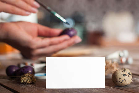 Blank greeting card with hand coloring egg on background. Preparation for Easter, traditional handmade decorations with empty paper. Greeting, art, hobby conceptの写真素材