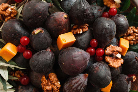 Delicious snack of fig, cheese and nuts closeup. Food background of gourmet meal for wine, fresh fruits and walnuts. Gourmet, delicatessen, appetizer conceptの写真素材