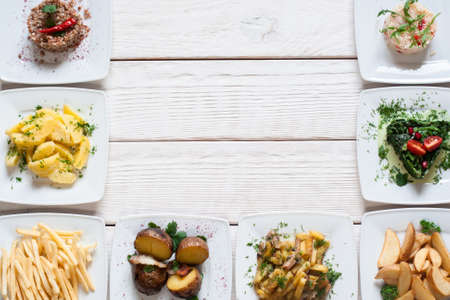 Fresh vegetable snacks on white table free space. Frame of plates with vegetarian food. Healthy eating, summer, buffet, fasting, vegan party, diet conceptの写真素材