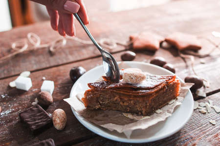 Sweet turkish baklava eating free space. Womans hand holding teaspoon and taking piece of traditional eastern pastry, closeup. Confectionery, restaurant, dessert conceptの写真素材