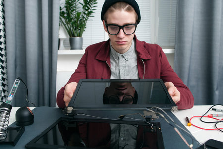 Laptop screens comparison free space. Young expert looking at two new digital monitors for notebook....