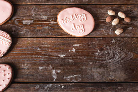 Cookie with wedding day sign on wood free space. Original invitation for marriage party on wooden table, flat lay. Bakery, dessert, cake conceptの写真素材