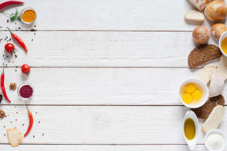 Red spices and bread frame on white wood free space. Top view on white wooden table with fresh food ingredients for making bread and spiced food, kitchen conceptの写真素材