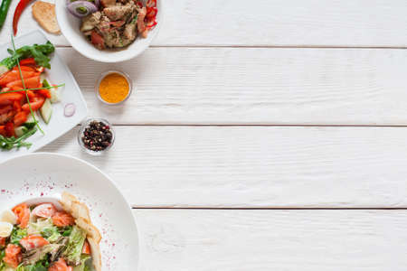 White wooden table with warm salads free space. Top view on kitchen desk with meat side dishes, flat lay. Buffet, banquet, party, menu conceptの写真素材