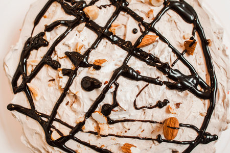 Delicious cake with white cream, almond and chocolate topping top view . Cookery business abstract...