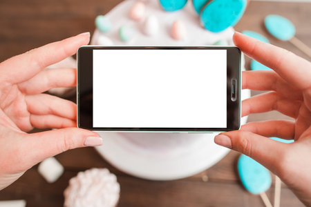 Food photography of white cake on wooden table background. Smartphone mockup with blank screen....