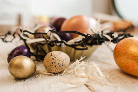 Painted eggs on the white wooden table closeup. Handmade decoration for easter celebration. House decor, tradition, craftsmanship conceptの写真素材