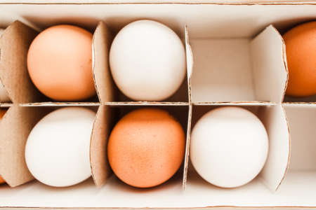 Fresh ginger and white eggs packed in a white paper container top view. Healthy protein food conceptの写真素材
