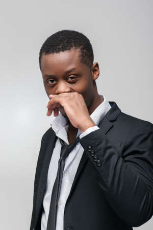 Afroamerican guy liar on grey background. Hiding truth, not telling, dishonest, sly, cunningの写真素材