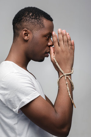 High-concentrated african american guy preparing himself, thinking of win, good luck, sport victory. Power of prayers, religion, belief, worship.の写真素材