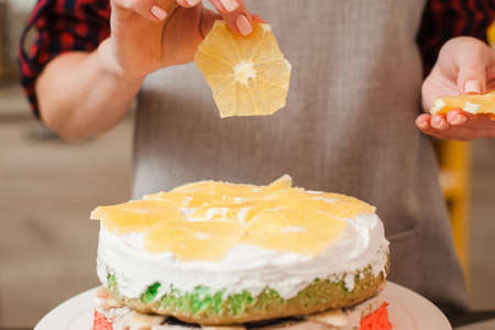 Orange decoration of homemade biscuit cake. Culinary blog. Creative cuisine, good housewife, colorful healthy food conceptの写真素材