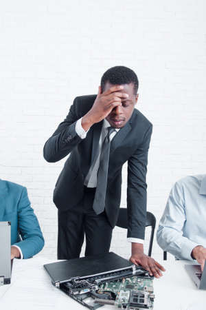 Bankruptcy of company. Disappointed and stressed leading manager with broken laptop. Stress, fail, problem at work conceptの写真素材