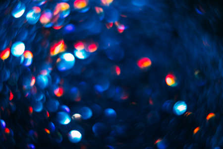 Abstract blurred glittering shine background, blue and red. Blur light bokeh. Christmas wallpaper decorations concept. New year holiday festive backdrop. Sparkle circle celebrations display.の写真素材