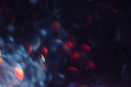 Abstract blurred glittering shine, blue and red. Blur light bokeh, night background. Christmas wallpaper decorations concept. New year holiday festive backdrop. Sparkle circle celebrations display.の写真素材
