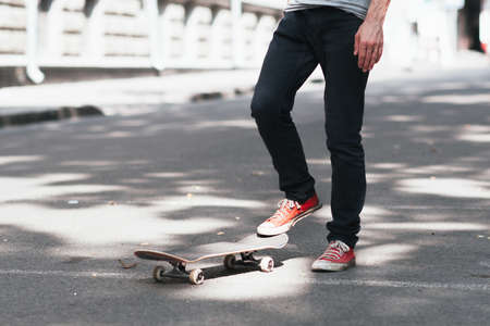 Fan active extreme urban sport fo young kid at city street. Unrecognizable skateboarder prepare for practice skateboard trick.の写真素材