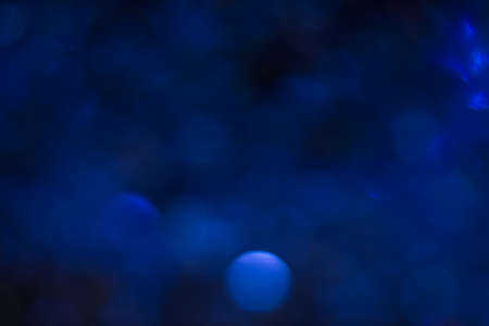 Abstract blur light bokeh, blue toned. Blurred glittering shine , night background. Christmas wallpaper decorations concept. New year holiday festive backdrop. Sparkle circle celebrations display.の写真素材