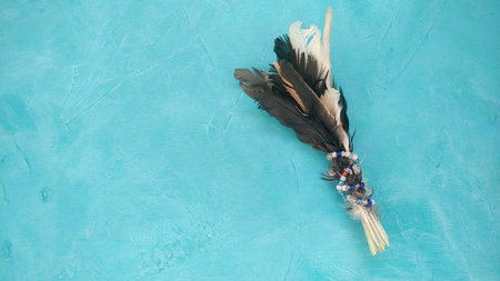 Bird feather decoration on teal background. Magic, rustic style, handmade conceptの写真素材