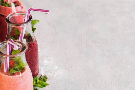 Bottles of smoothie on white background. Fruit drinks from strawberry, cherry and wineberry,...