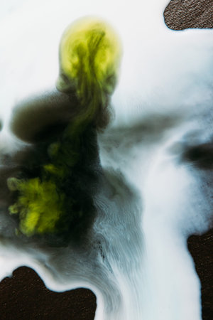 Abstract image of colorful blots of liquid on black background. Watercolor streaks of white paint...