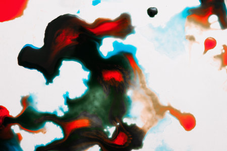 Abstract image of colorful splashes on white background. Watercolor plumps of bright red, dark green and turquoise blots of paint on surfaceの写真素材