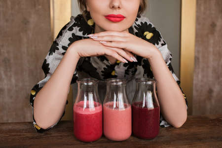 Housewife preparing fresh smoothies at home. Fruit drinks from strawberry, cherry and wineberry, refreshment in hot weather and summer period, healthy food close upの写真素材