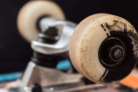 Close up skateboard truck and wheels on black background. Repairing of professional extreme sport devices and skateboarding elements. Chassis, kingpin, bushing, hangerの写真素材