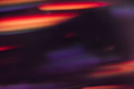 Abstract background of defocused light motion blur. Glowing urban backdrop, sparkle shiny purple, orange and red lines wallpaper, night city leds bokehの写真素材