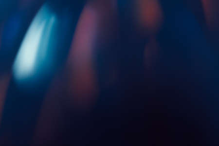 Abstract background of blurs in motion on black. Bokeh of defocused reflection blurred lights on dark backdrop, mirror-like surface, magic nature aroundの写真素材