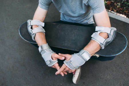Professional skater takes breath after training. Extreme sport challenge and competition, skateboarder equipment and urban lifestyle and culture of young peopleの写真素材