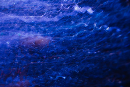 Abstract background of lines in motion on black. Bokeh of defocused curves, blurred neon white and...