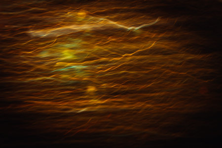 Abstract background of blurred yellow lines in motion similar to sunset haze. Bokeh of defocused...