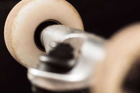 Close up skateboard wheels on black background, focus on background. Repairing and adjustment of professional extreme sport devices and skateboarding elements. Chassis, kingpin, hangerの写真素材