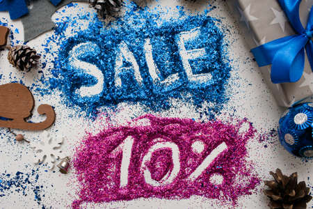 Sales on Christmas and New Year holidays, top view close up. Colorful decoration with informative inscription of 10 pct discount for shop-windows, shopping malls and advertizing background conceptの写真素材