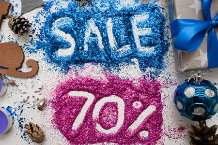Sales on Christmas and New Year holidays, top view close up. Colorful decoration with informative inscription of 70 pct discount for shop-windows, shopping malls and advertizing background conceptの写真素材