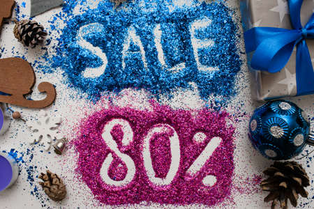 Sales on Christmas and New Year holidays, top view close up. Colorful decoration with informative inscription of 80 pct discount for shop-windows, shopping malls and advertizing background conceptの写真素材